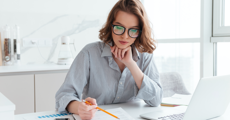 Woman, wearing glasses, working at home