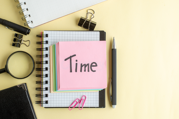 Top view of the word “time” written on a note