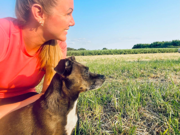 Mujer y su perro mirando la naturaleza