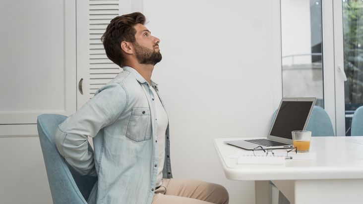 Hombre con dolor de espalda después de estar sentado por mucho tiempo