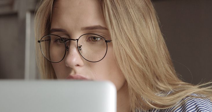 Eine Frau liest konzentriert auf ihrem Laptop