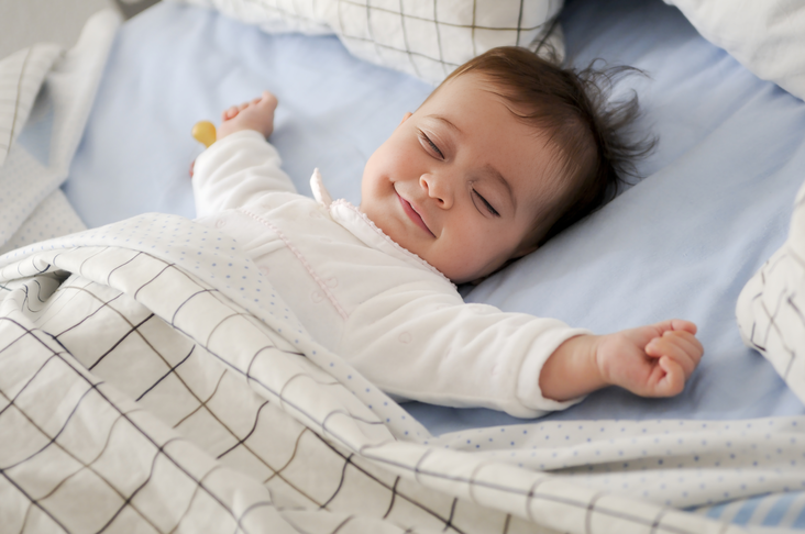 photo smiling baby lying on a bed