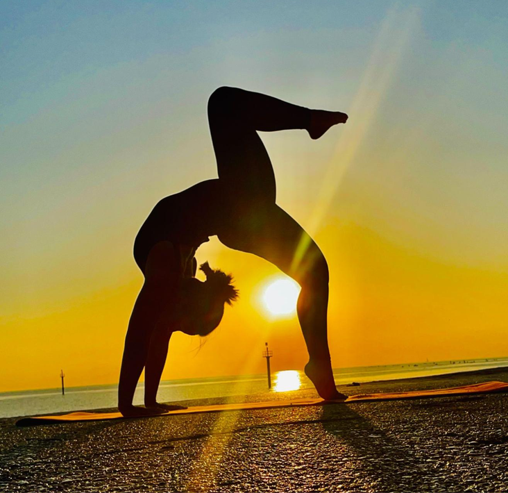 Yoga. Postura del puente (Setu Bandhasana), con una pierna levantada.